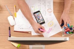 A desk with a phone, notes and design sketches to symbolise free marketing tools
