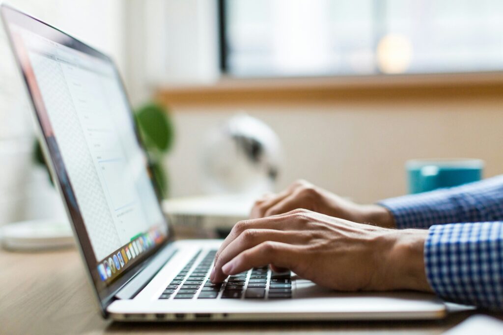 Person writing on a laptop, showing how to plan and write a brand storytelling article for a small business.