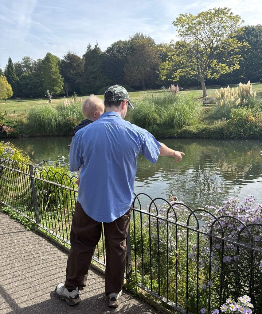 A dad and baby looking at ducks on the pond in Golders Hill Park, one of many fun things to do with kids in London
